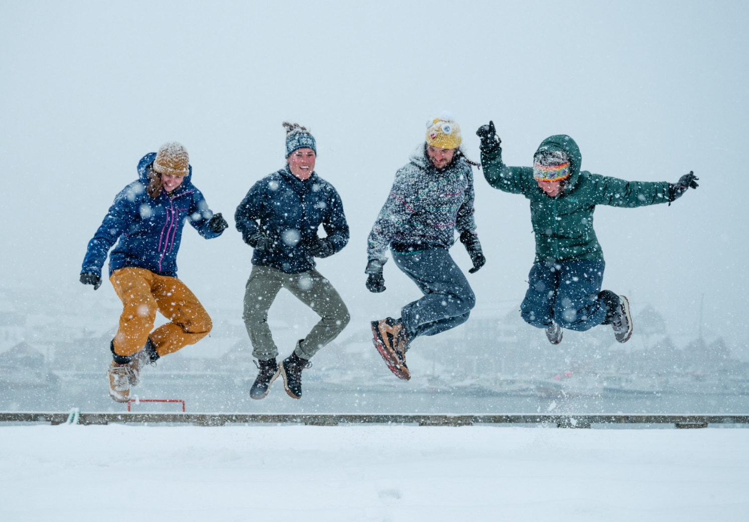 Shop our holiday gift guide featuring 4 people jumping in the snow.