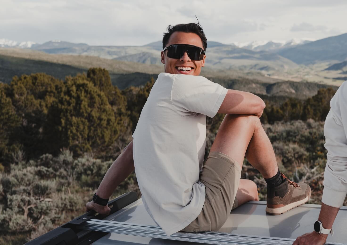 Shop Forsake men's featuring a man sitting on top of a car. 