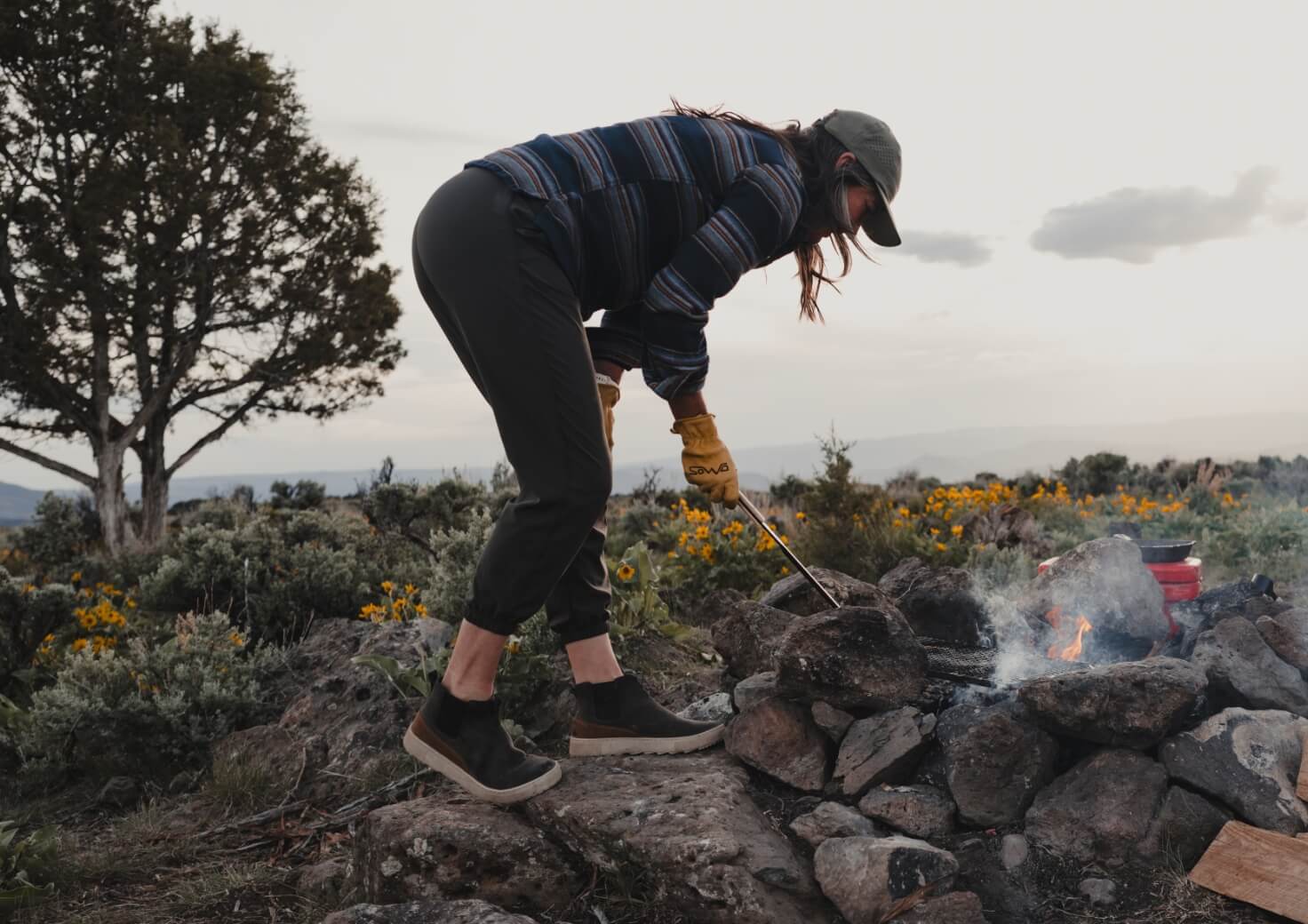 Shop Forsake women's featuring a woman making a fire.