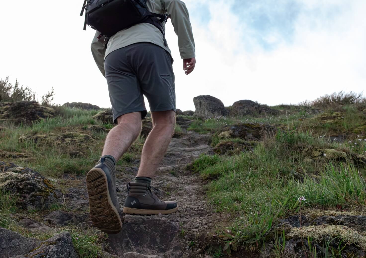 Shop Forsake men's featuring a man hiking up a hill.