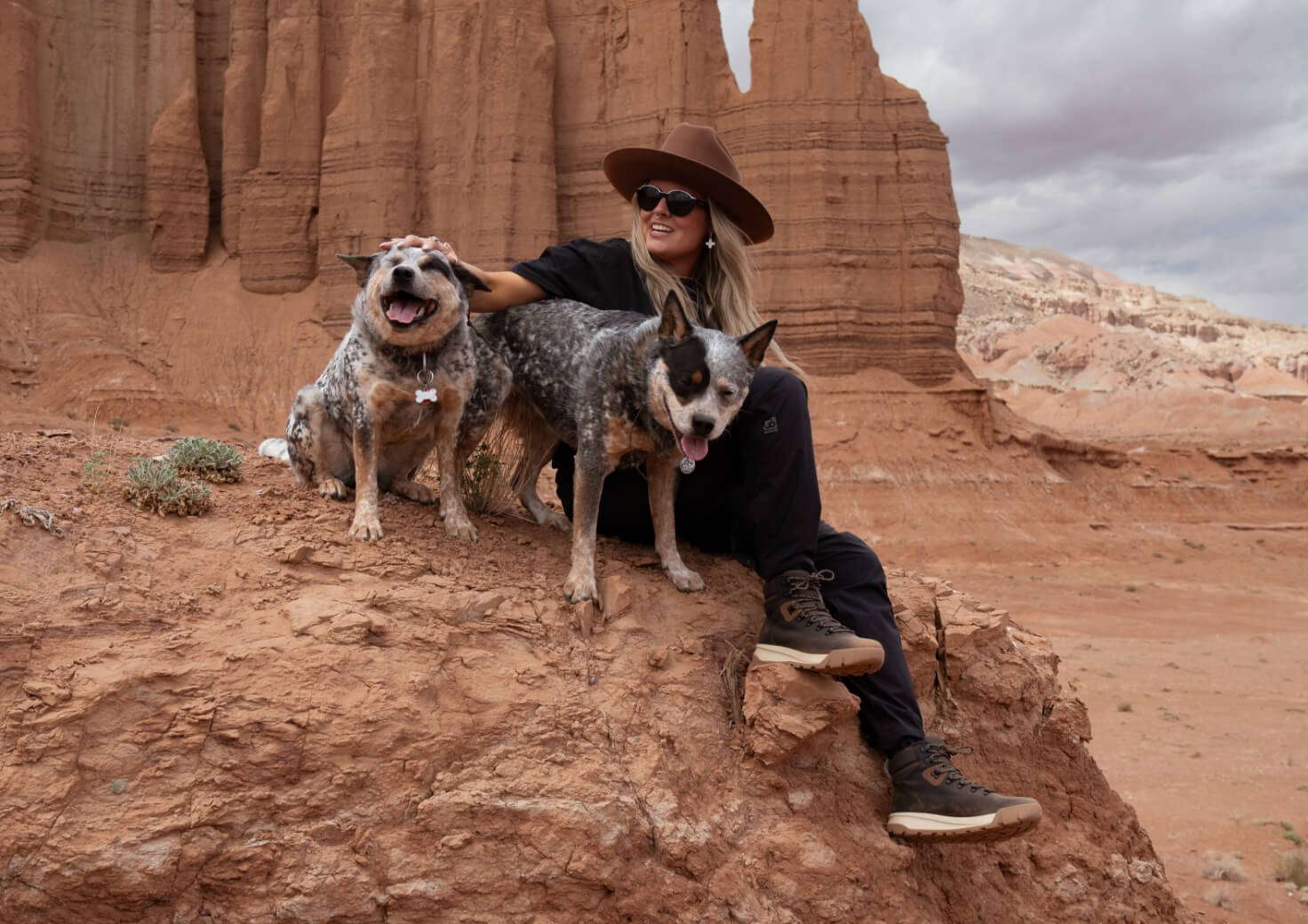 Shop Forsake women's featuring a woman on a rock with 2 dogs. 