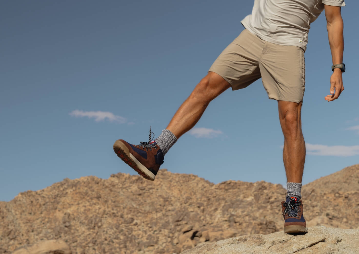 Shop Forsake men's featuring the Fifteen mid in navy/brown on top of a rock.